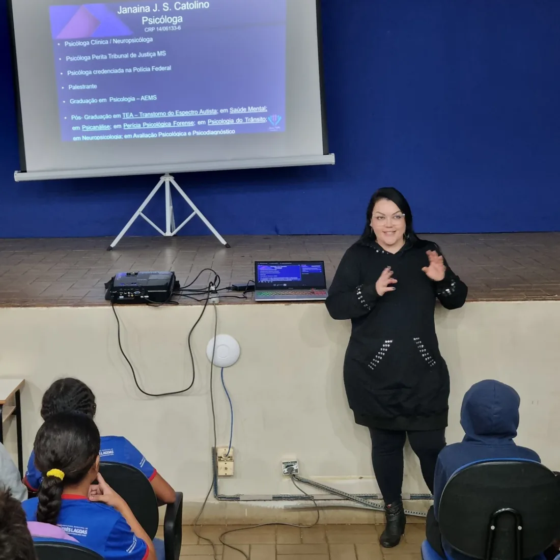 Janaína Catolino ministrando uma palestra com apresentação projetada